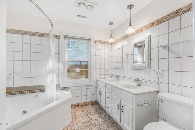 a bathroom with a tub sink and mirror