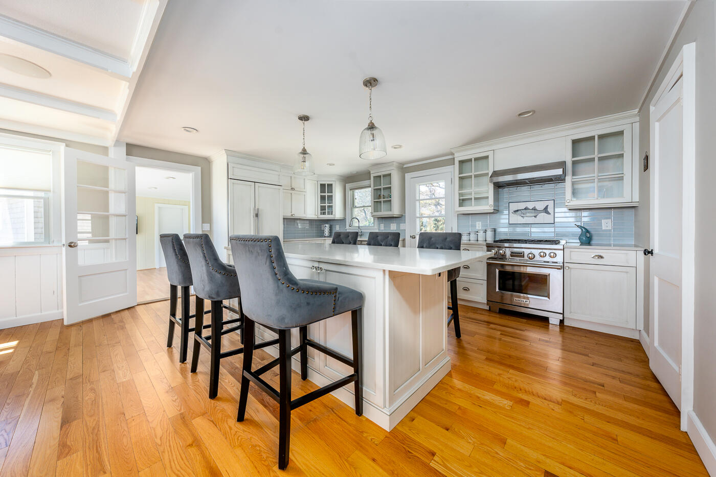 157 Brownell Road Eastham, MA 02642 - Photo 12 of 45 a kitchen with stainless steel appliances granite countertop a stove top oven a sink dishwasher white cabinets and a dining table with wooden floor