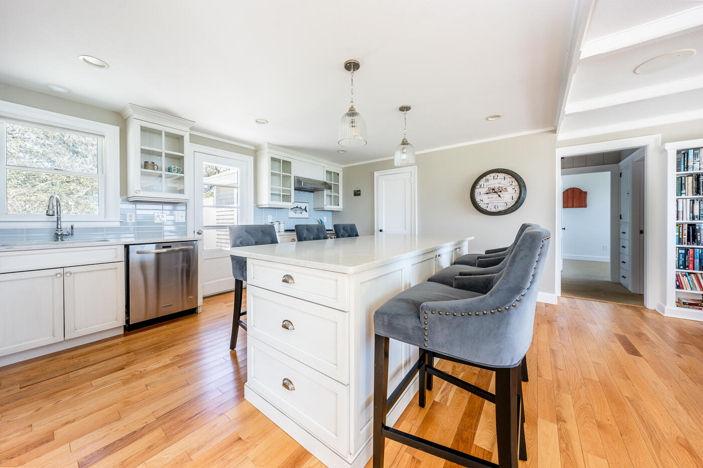 157 Brownell Road Eastham, MA 02642 - Photo 31 of 45 a kitchen with kitchen island granite countertop a sink a stove cabinets and wooden floor