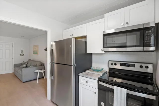 a kitchen with a refrigerator stove and cabinets