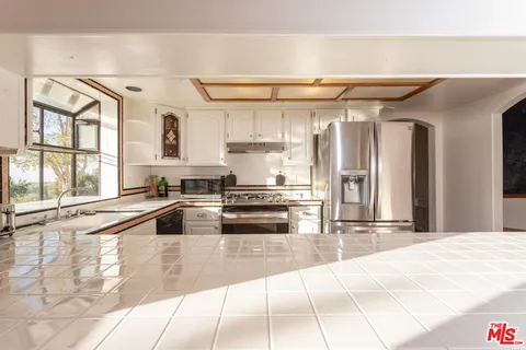 a kitchen with granite countertop a sink and a stove top oven