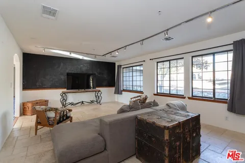 a living room with furniture a flat screen tv and a large window
