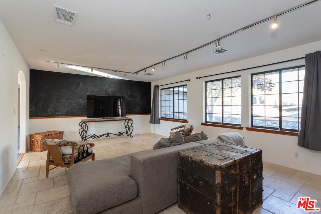 29243 Piani Road Pearblossom, CA 93553 - Photo 15 of 64 a living room with furniture a flat screen tv and a large window