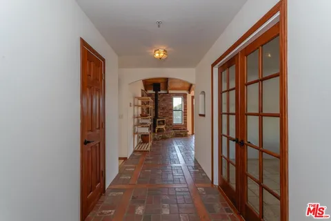 a view of a hallway with wooden floor and windows