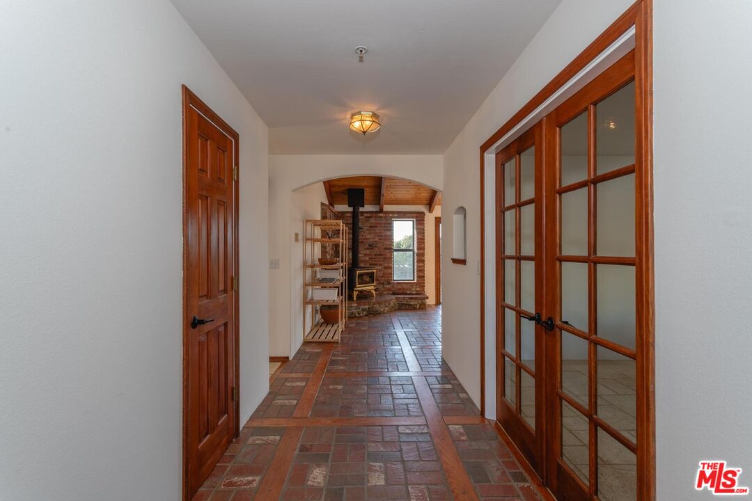 29243 Piani Road Pearblossom, CA 93553 - Photo 6 of 64 a view of a hallway with wooden floor and windows