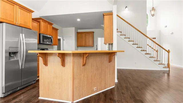 a kitchen with stainless steel appliances granite countertop hardwood floor sink stove and wooden cabinets