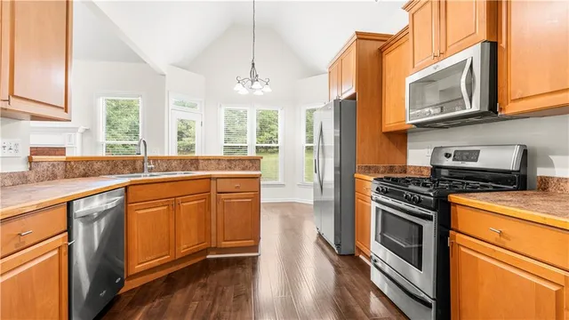 a kitchen with stainless steel appliances granite countertop a refrigerator and a stove top oven