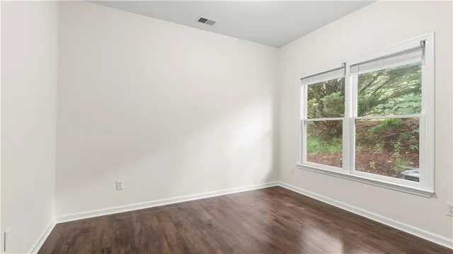 an empty room with wooden floor and a window