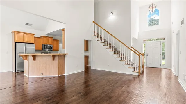 a view of a hallway with wooden floor and staircase