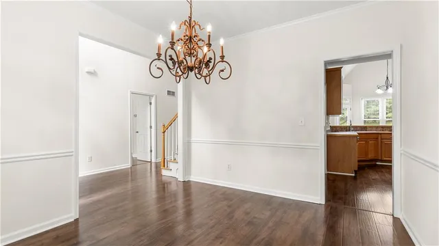 a view of a room with wooden floor and chandelier