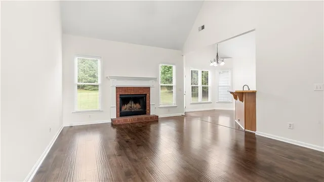 a view of a livingroom with wooden floor and a fireplace