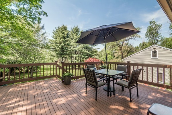 a view of deck with furniture and umbrella