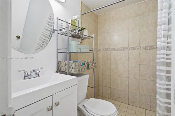 a bathroom with a granite countertop sink a toilet and shower