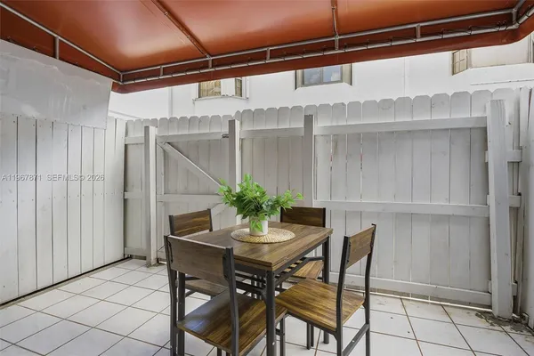 a dining room with lots of wooden furniture and potted plants