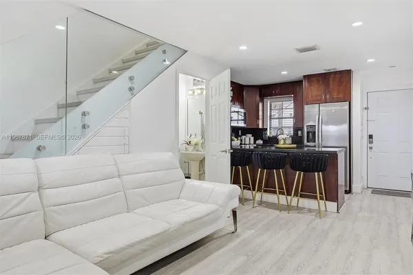 a living room with furniture and a dining table with wooden floor