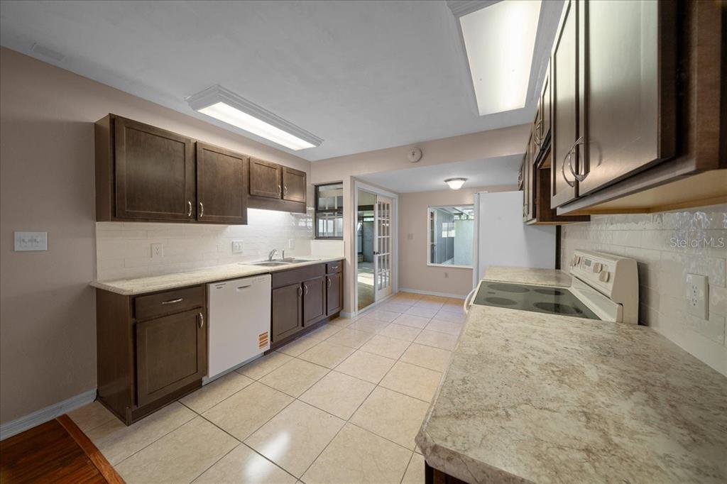 3702 Northeast 17th Street Ocala, FL 34470 - Photo 12 of 63 a large white kitchen with a sink stainless steel appliances and cabinets