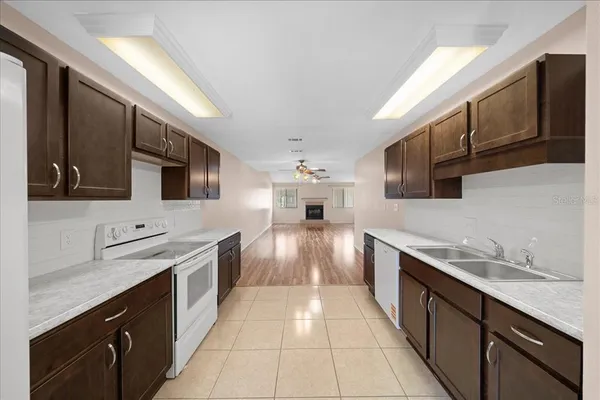 a large white kitchen with a sink stainless steel appliances and cabinets