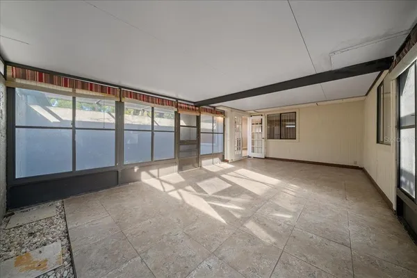 an empty room with a chandelier fan and closet area