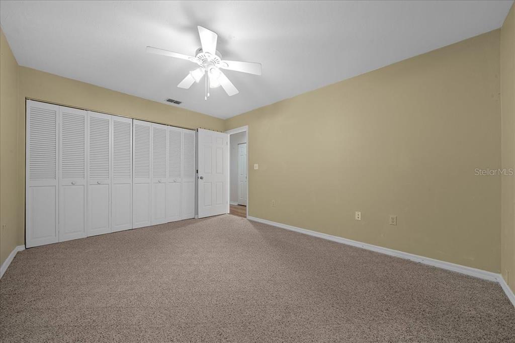 3702 Northeast 17th Street Ocala, FL 34470 - Photo 25 of 70 an empty room with a chandelier fan and closet area