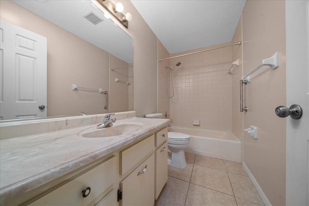 3702 Northeast 17th Street Ocala, FL 34470 - Photo 27 of 70 a bathroom with a granite countertop sink a toilet and shower