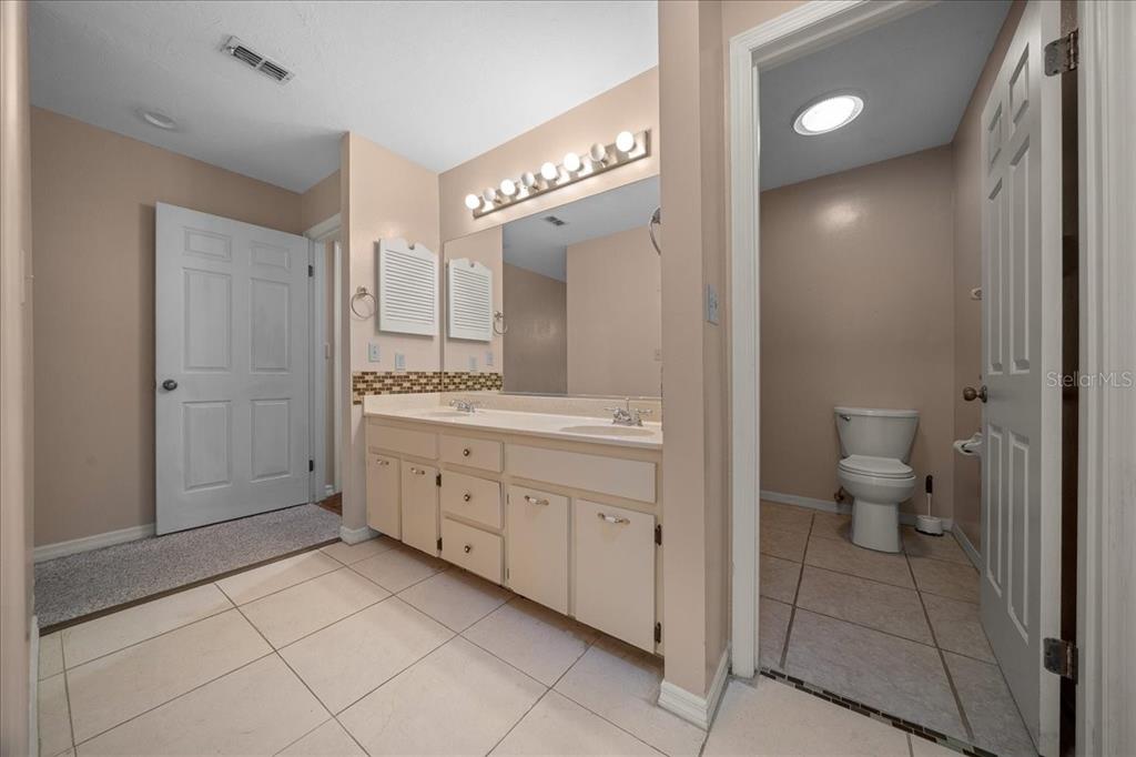 3702 Northeast 17th Street Ocala, FL 34470 - Photo 32 of 70 a spacious bathroom with a double vanity sink a toilet and a large mirror