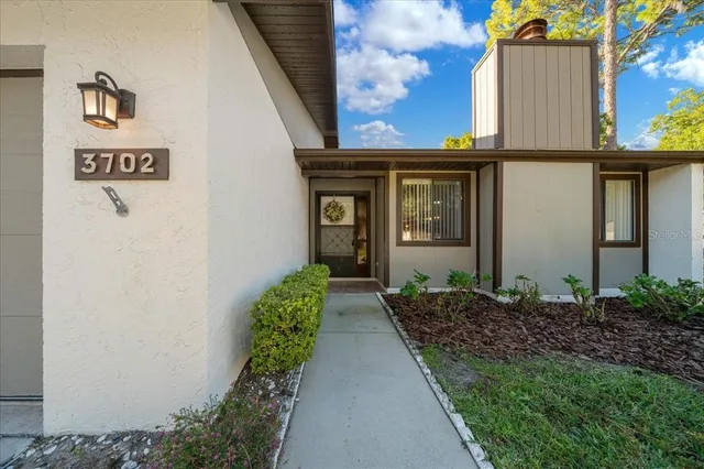 an empty room with wooden floor fireplace and windows