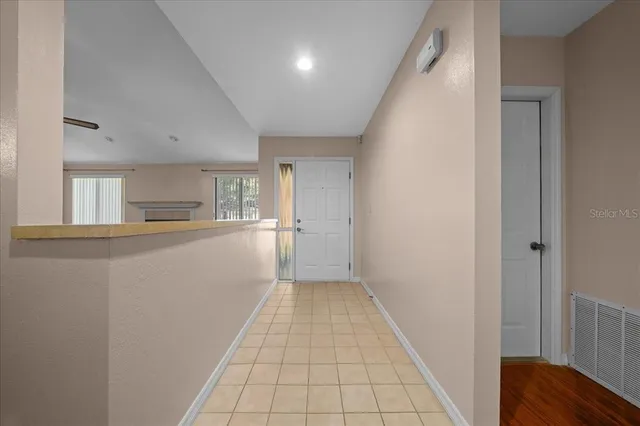 an empty room with wooden floor fireplace and windows