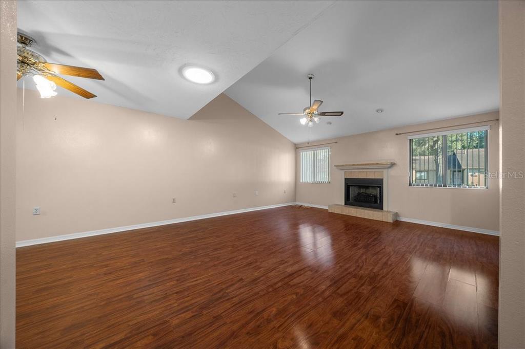 3702 Northeast 17th Street Ocala, FL 34470 - Photo 6 of 63 an empty room with wooden floor fireplace and windows