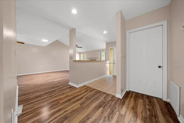 an empty room with wooden floor fireplace and windows