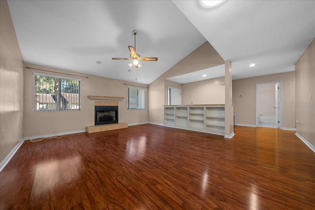 3702 Northeast 17th Street Ocala, FL 34470 - Photo 7 of 63 an empty room with wooden floor fireplace and windows