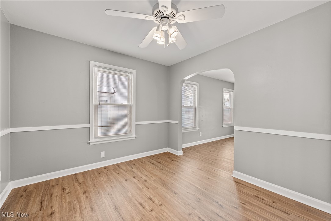 4041 Wilmington Road Cleveland, OH 44121 - Photo 9 of 38 Empty room featuring arched walkways, light wood-style flooring, and a ceiling fan