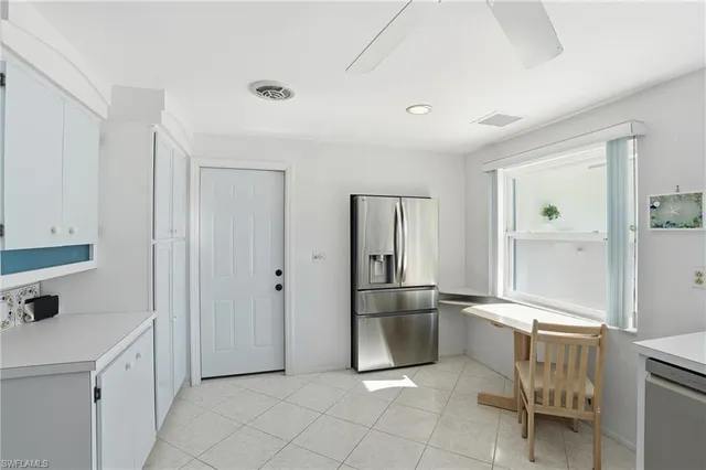 a kitchen with white cabinets and refrigerator