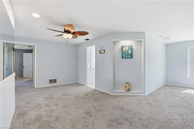 an empty room with closet and a chandelier fan