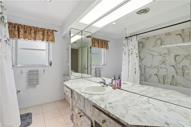 a bathroom with a granite countertop sink a mirror and a shower