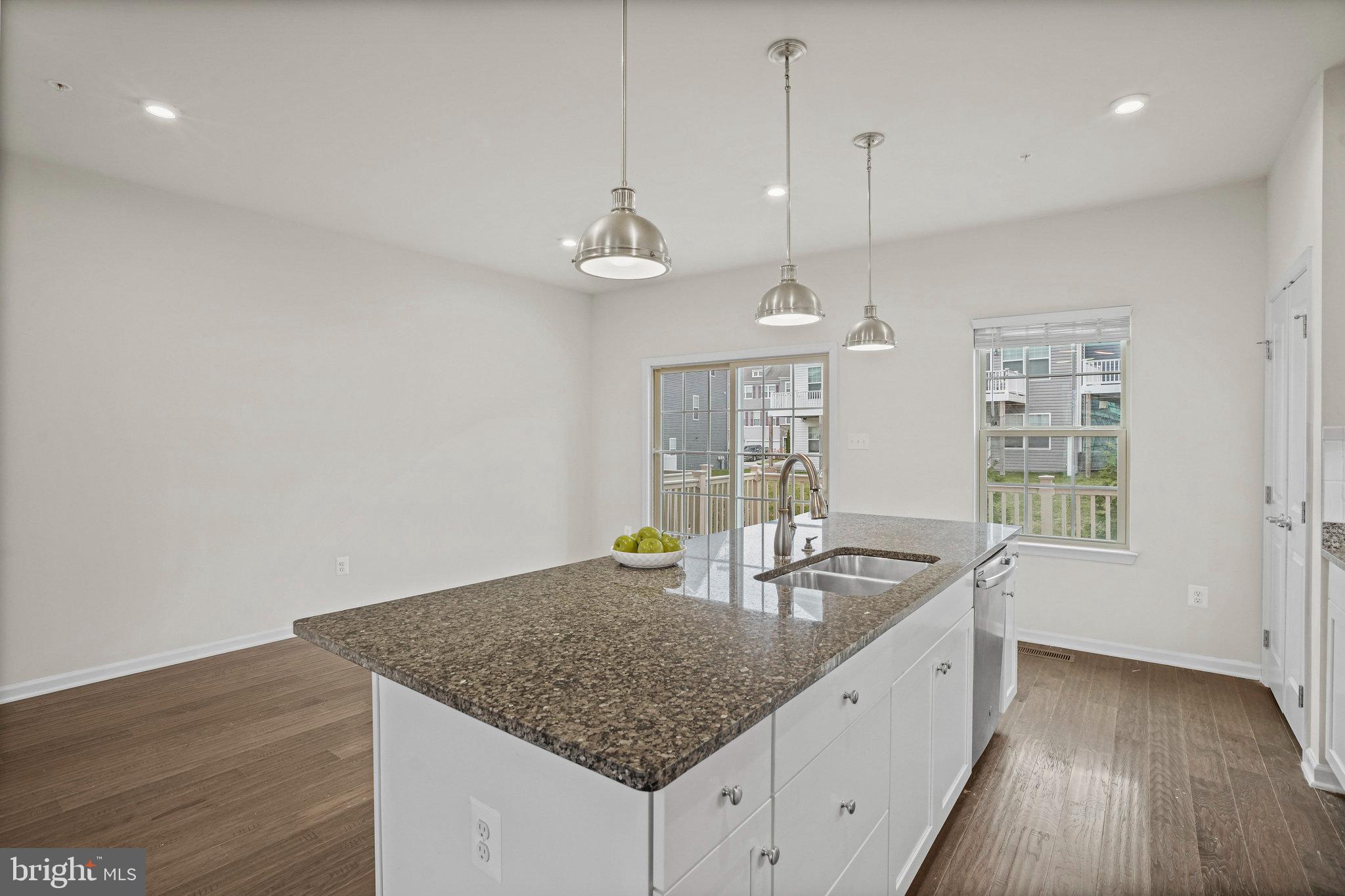 2829 Fredericksburg Road Hanover, MD 21076 - Photo 10 of 37 a kitchen with granite countertop a sink a counter top space and living room area