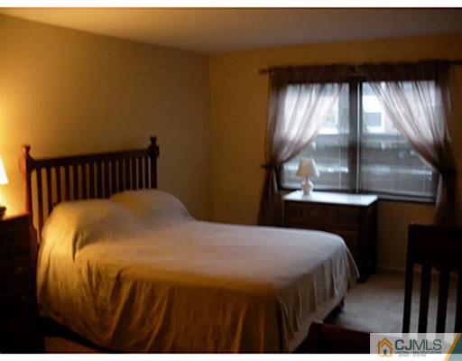 1618 Raspberry Court Edison, NJ 08817 - Photo 5 of 10 a bed sitting in a bedroom next to a window