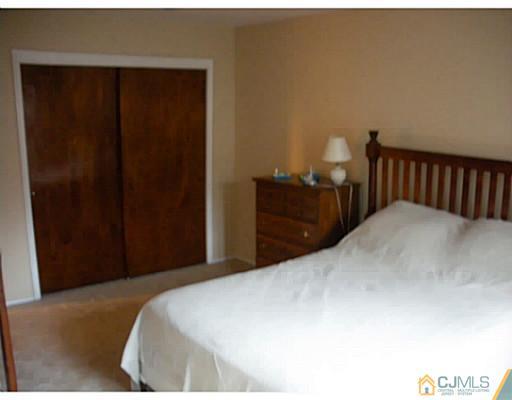 1618 Raspberry Court Edison, NJ 08817 - Photo 6 of 10 a bedroom with a bed and a lamp