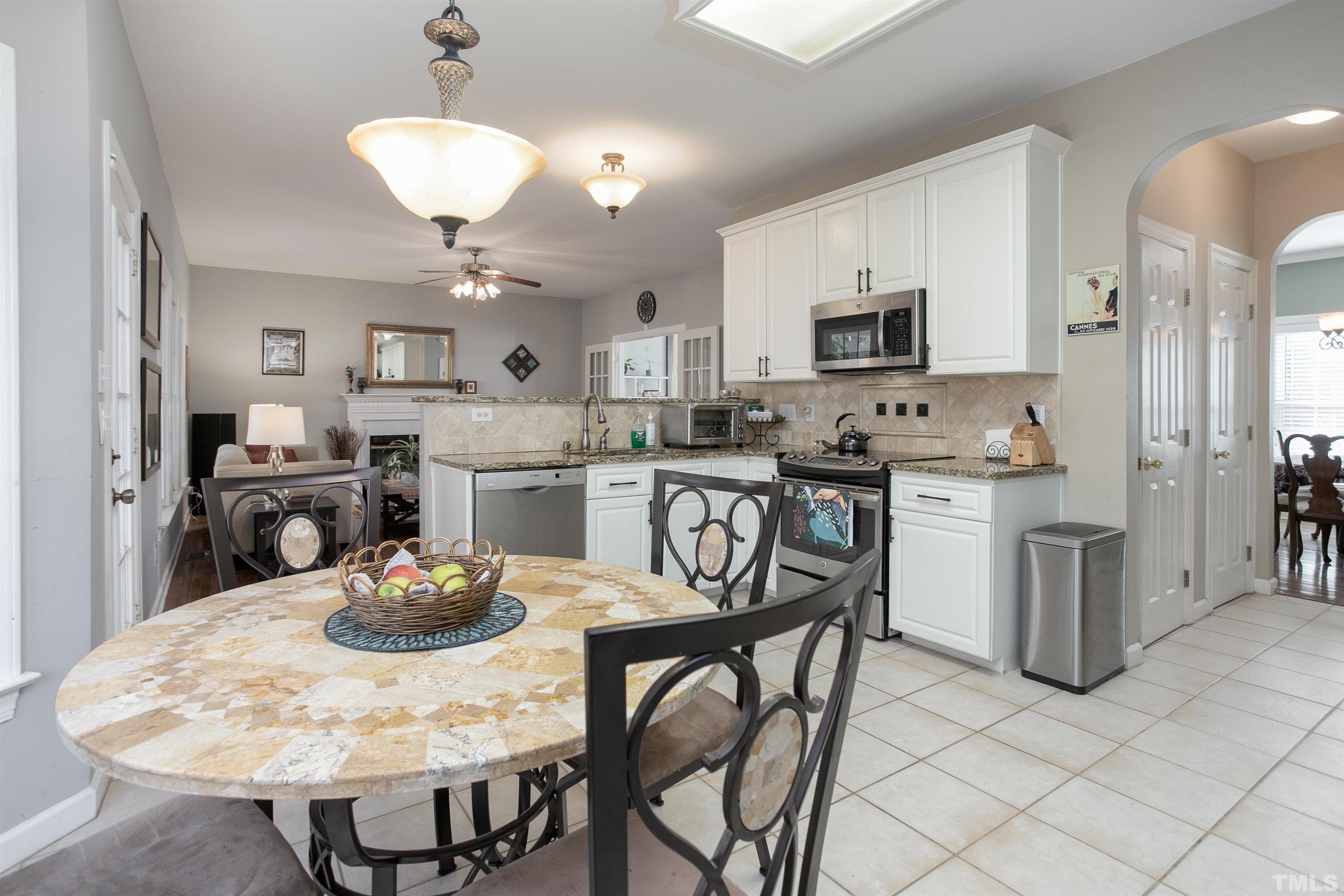 8832 Braceridge Road Raleigh, NC 27613 - Photo 21 of 40 a kitchen with stainless steel appliances kitchen island granite countertop a dining table and chairs