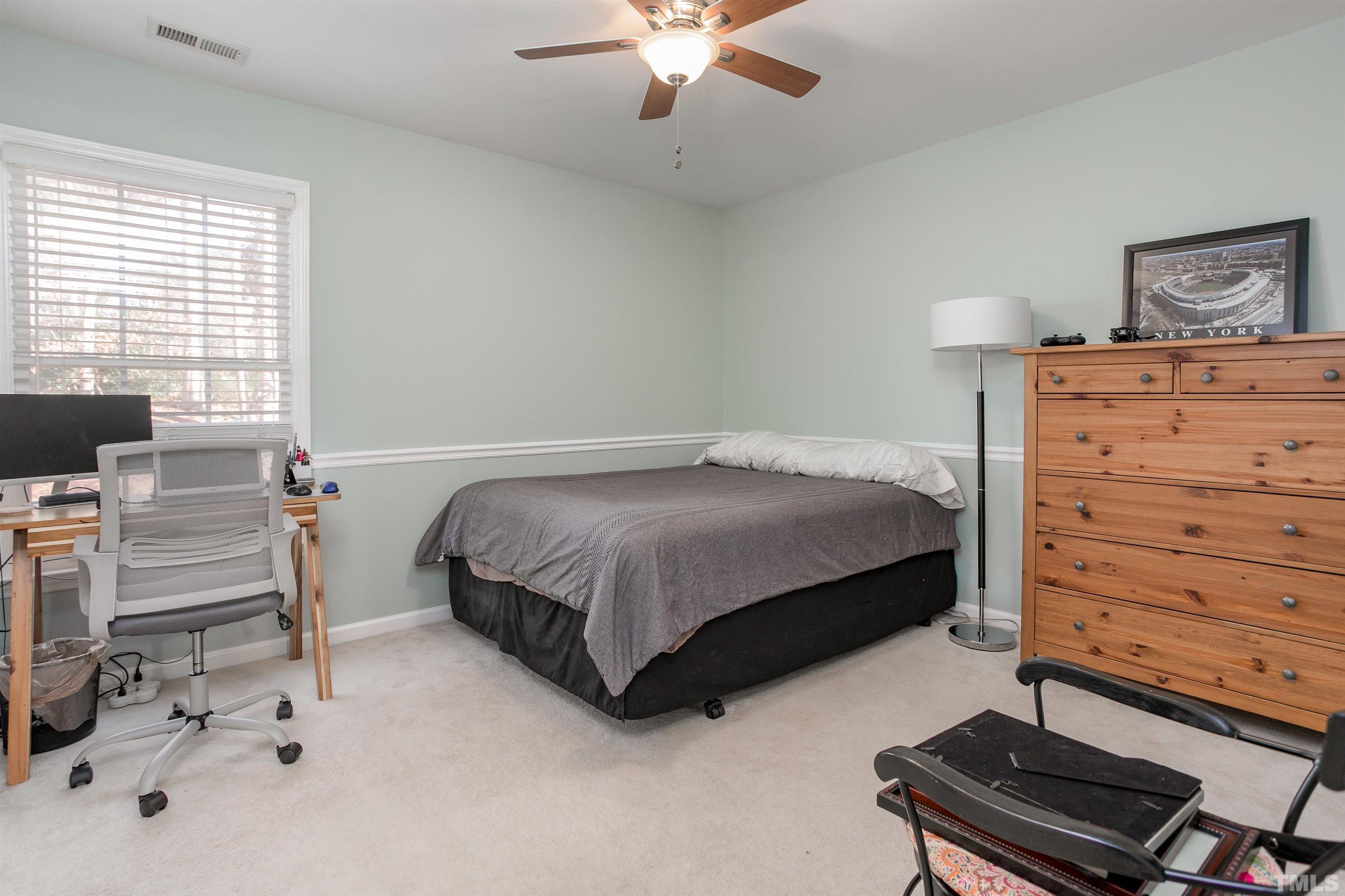 8832 Braceridge Road Raleigh, NC 27613 - Photo 29 of 40 a bedroom with a bed and a chandelier