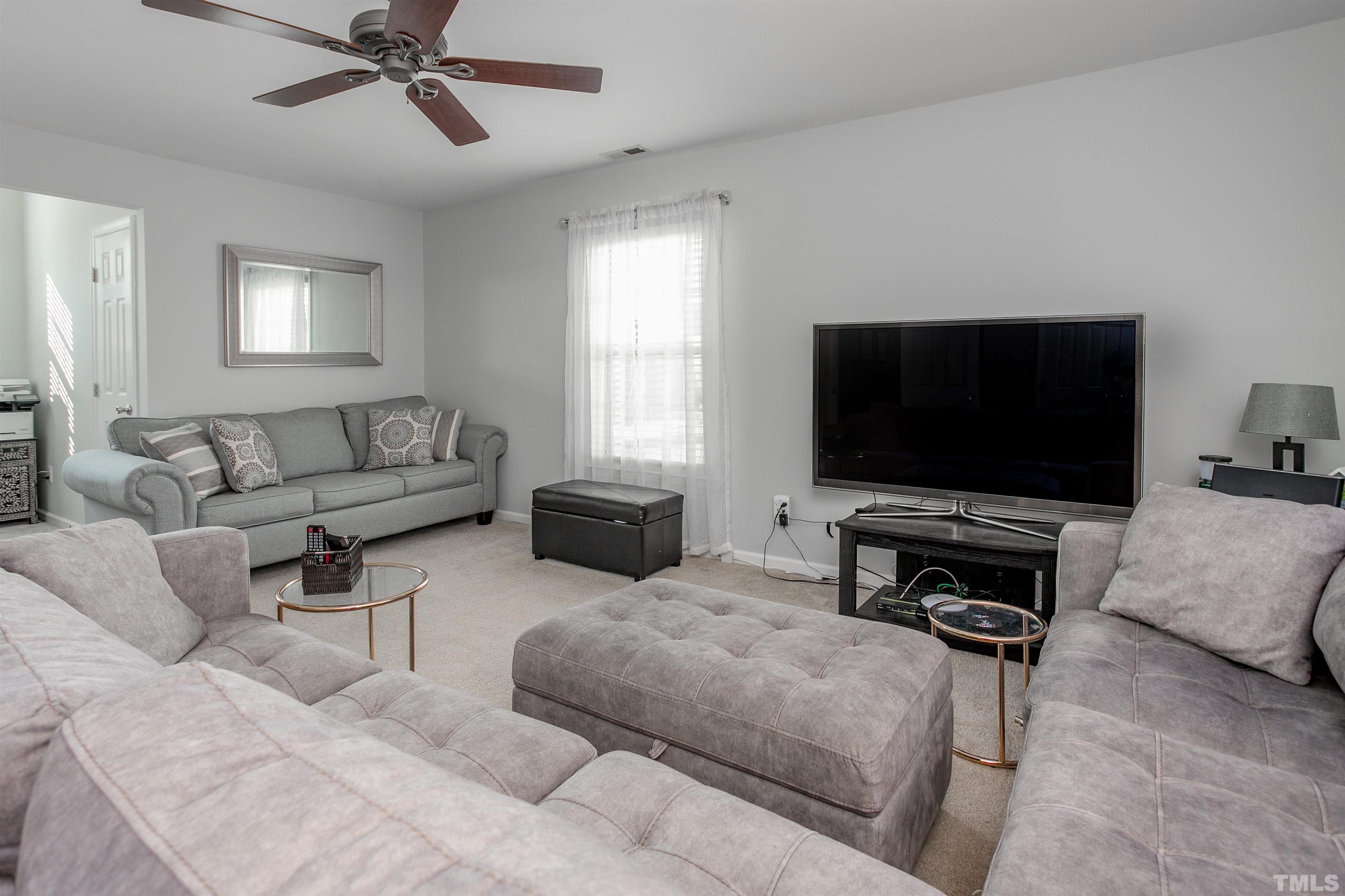 8832 Braceridge Road Raleigh, NC 27613 - Photo 31 of 40 a living room with furniture and a flat screen tv
