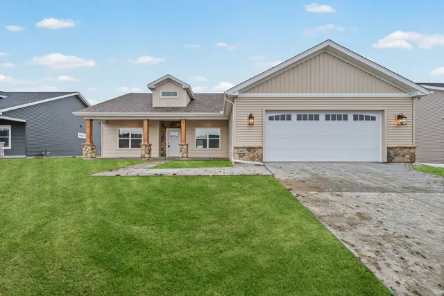 a front view of a house with a yard and garage