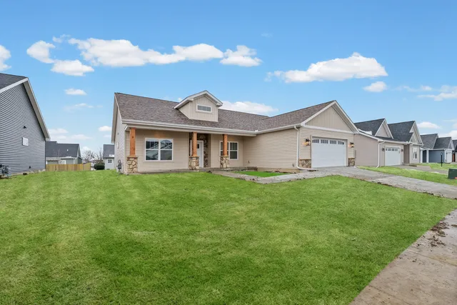 a view of a white house with a yard table and chairs