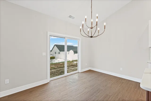 a large kitchen with white cabinets stainless steel appliances and wooden floor