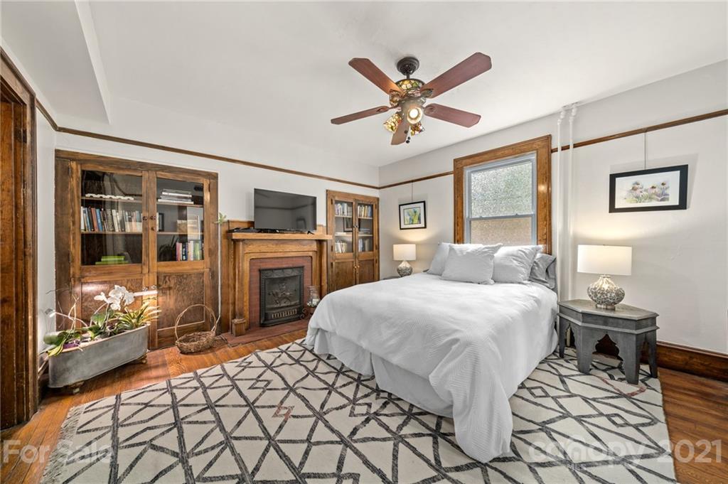 56 Pearson Drive Asheville, NC 28801 - Photo 16 of 44 a spacious bedroom with a bed and dresser with mirror