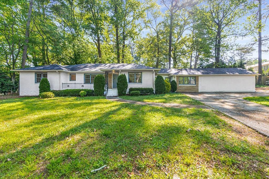 a view of a house with a patio and a yard