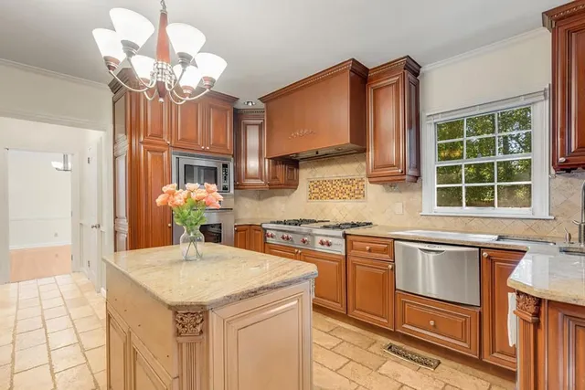 a kitchen with stainless steel appliances granite countertop a sink a stove and a refrigerator