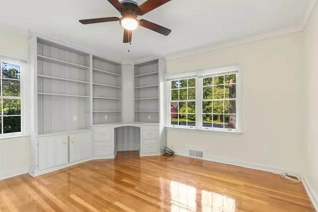 a view of an empty room with a window and wooden floor