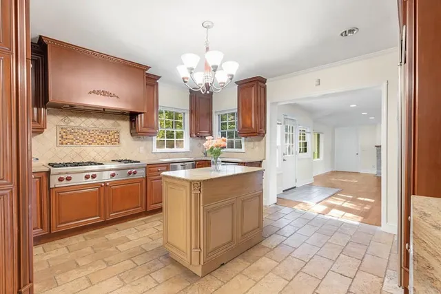 a large kitchen with granite countertop a stove a sink and a refrigerator