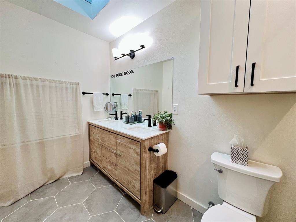 310 West 15th Street Irving, TX 75060 - Photo 13 of 30 a bathroom with a sink toilet and vanity