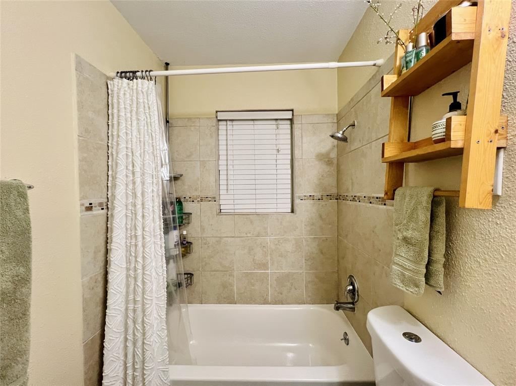 310 West 15th Street Irving, TX 75060 - Photo 17 of 30 a bathroom with a shower a bathtub and a shower